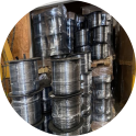 Stack of metal barrels in a warehouse.