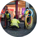 Worker using equipment on a city sidewalk.